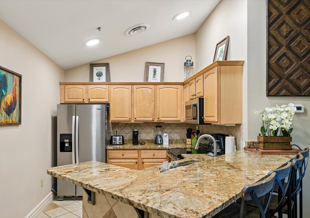 Your fully equipped kitchen awaits with granite counters, stainless appliances, and breakfast bar seating for easy meal prep and casual dining.