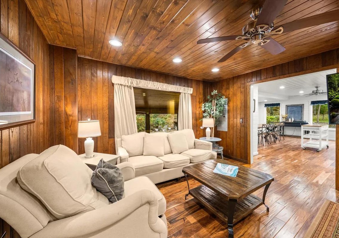Settle into the warm embrace of rich wood paneling and plush seating, where rustic charm meets modern comfort in your inviting living space.