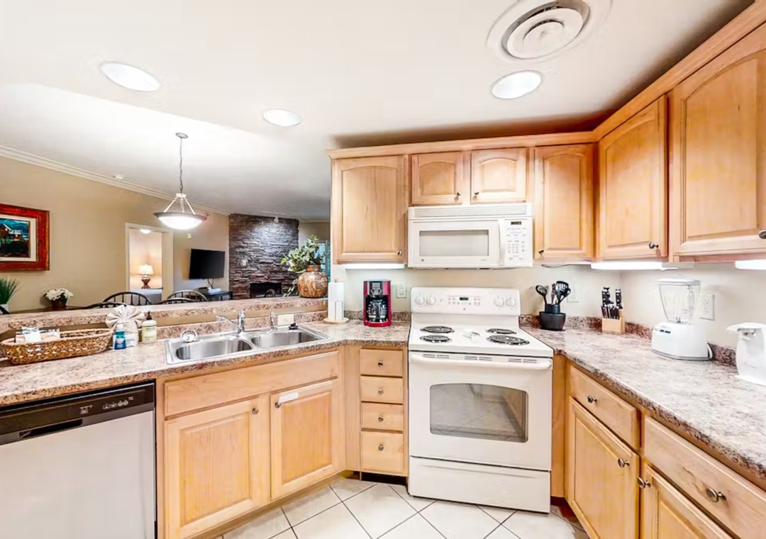 Step into your fully equipped kitchen featuring granite countertops, warm wood cabinets, and everything you need to create memorable meals during your stay.