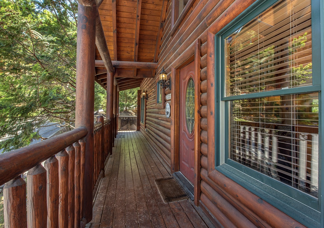 Step onto your private wraparound deck, where rustic log railings frame forest views and warm cabin charm welcomes you home.