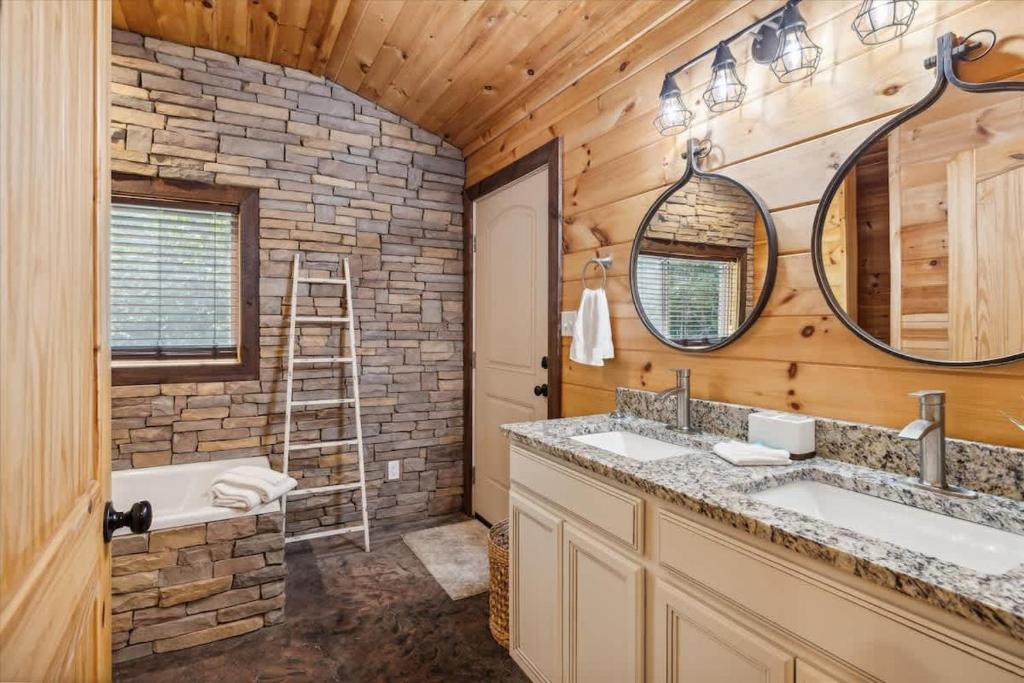 Unwind in your private retreat with rustic stone accents, warm wood tones, and dual vanities that blend mountain charm with modern comfort.