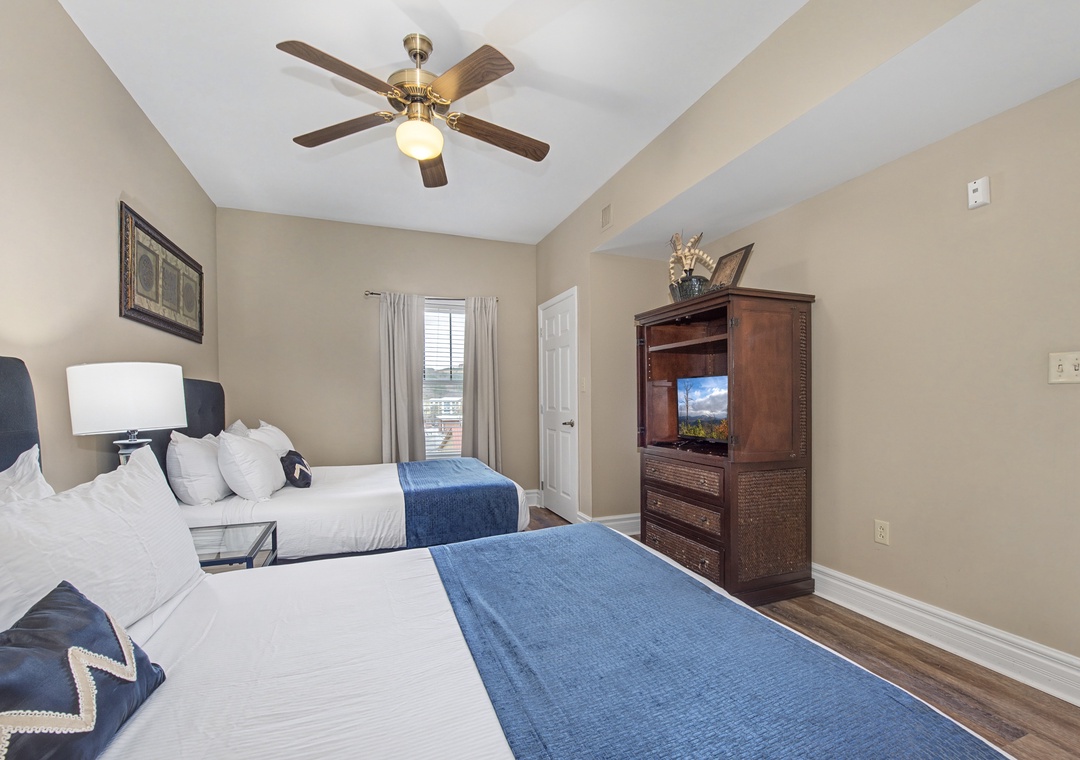 Sleep peacefully in your spacious twin bedroom with crisp linens, entertainment center, and gentle ceiling fan keeping you comfortable all night.
