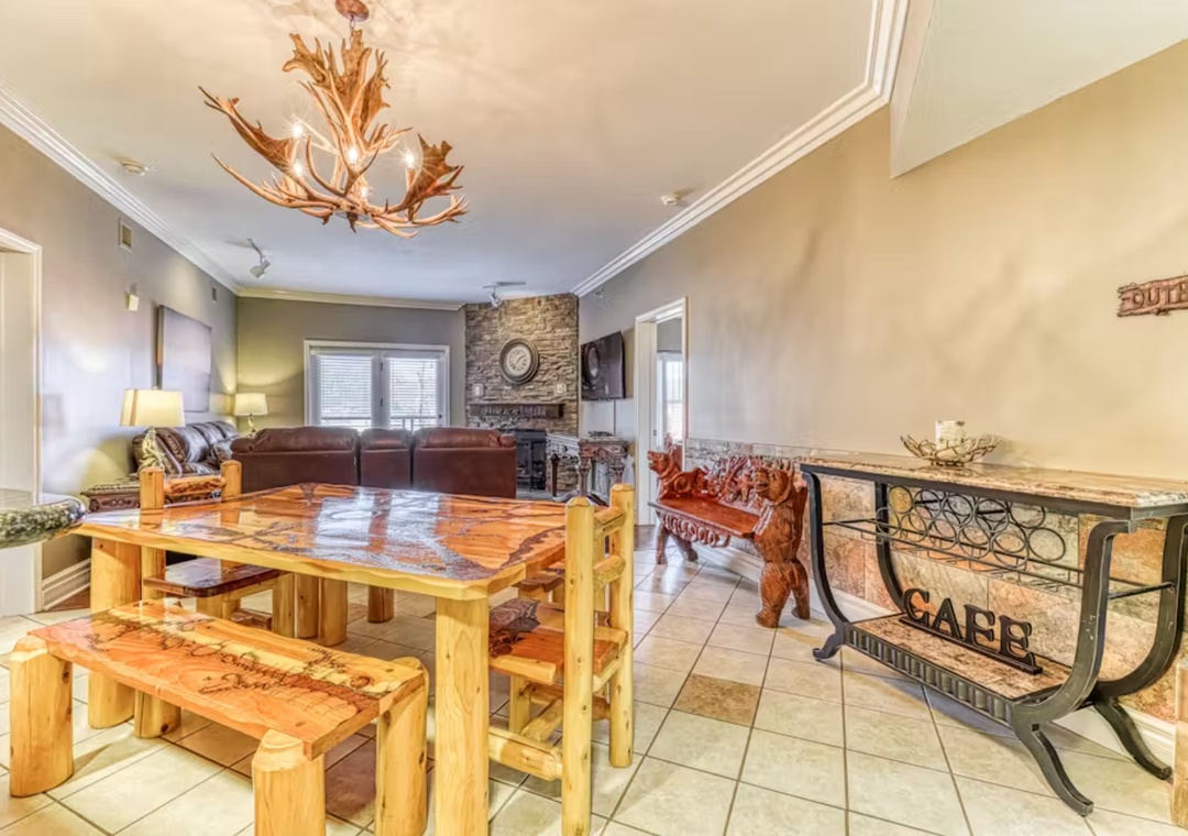 Gather around the handcrafted wooden dining table where your family meals become cherished memories beneath the rustic antler chandelier.