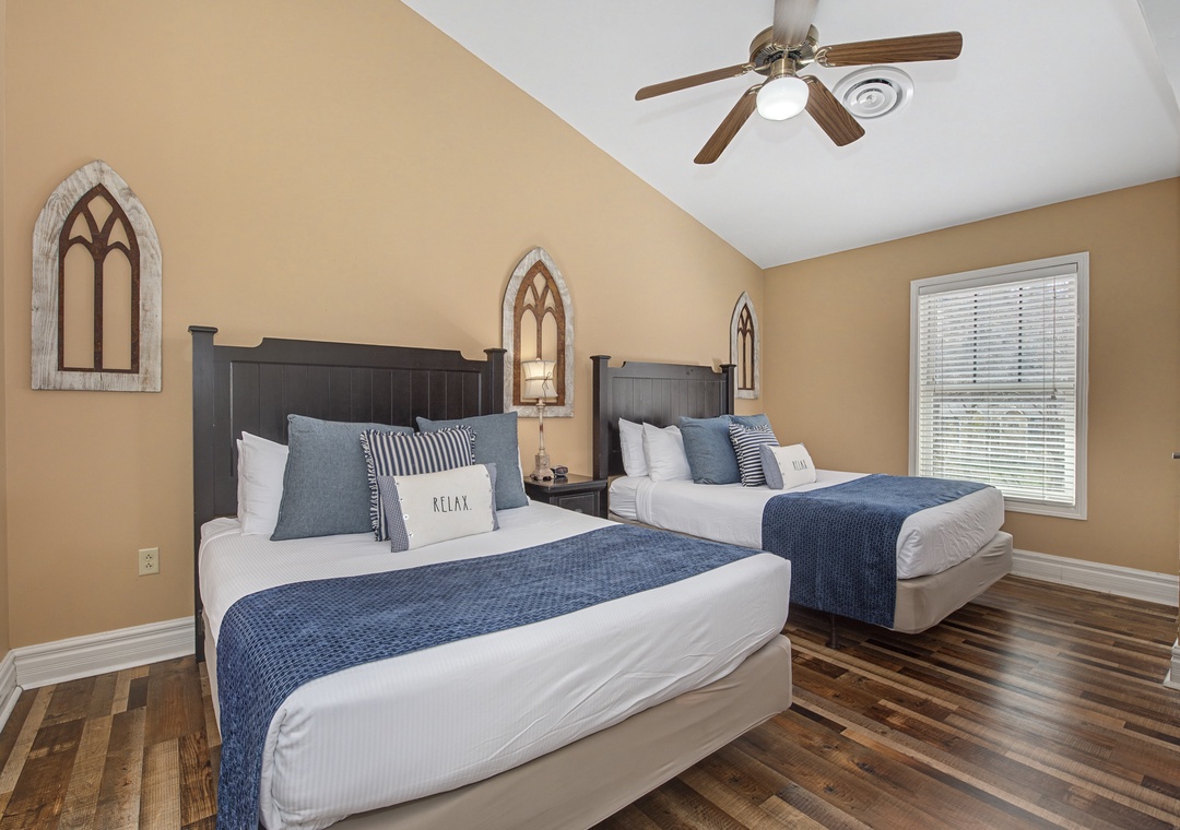 Unwind in your serene twin bedroom with crisp linens, rich hardwood floors, and a cooling ceiling fan for perfect comfort.