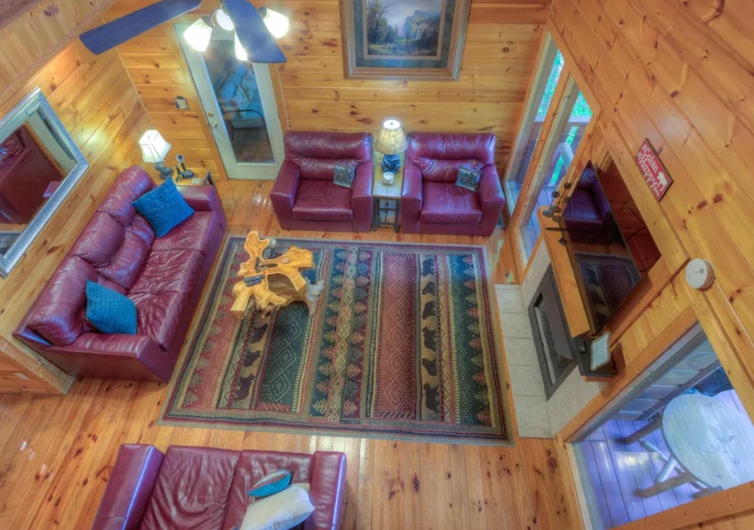 Admire the soaring vaulted ceiling and rich pine walls from this bird's-eye view. Plush leather seating invites you to unwind in a space that balances rustic charm with modern comfort.