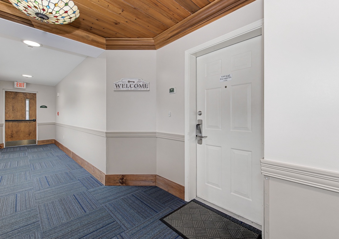 Elegant hallway with warm wood ceiling details and welcoming decor creates your perfect arrival experience.