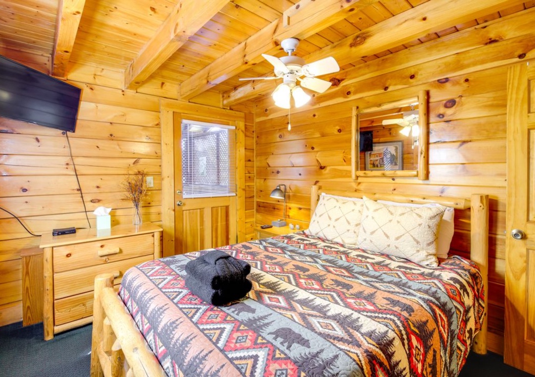 Cozy up in your rustic log cabin bedroom featuring exposed beam ceilings and Native American-inspired bedding for a perfect mountain getaway.