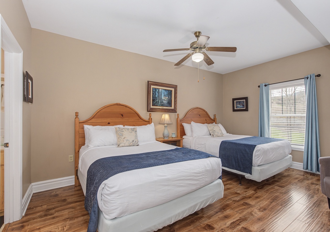 Your comfortable twin bedroom features two queen beds with rustic wooden headboards, creating a cozy retreat with warm lighting and peaceful ambiance.