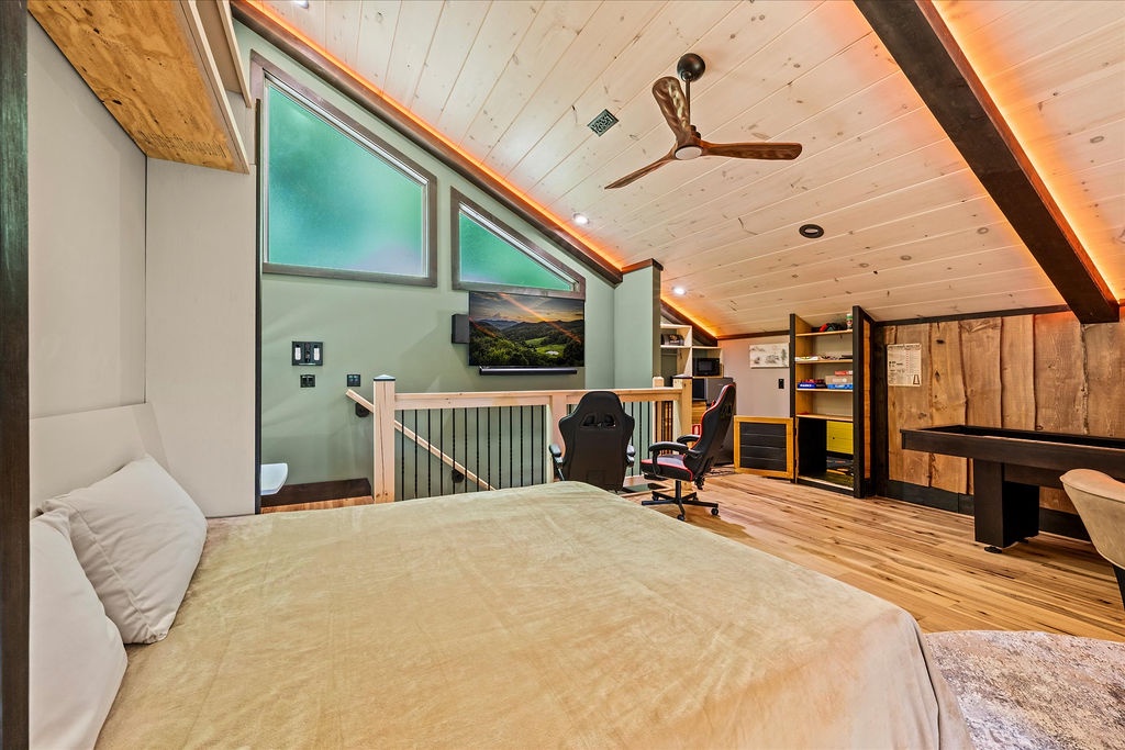 Unwind in your loft bedroom where rustic wood beams meet modern comfort. Cozy up in the plush bed, enjoy entertainment on the wall-mounted TV, or settle into the gaming chairs for a fun evening in.