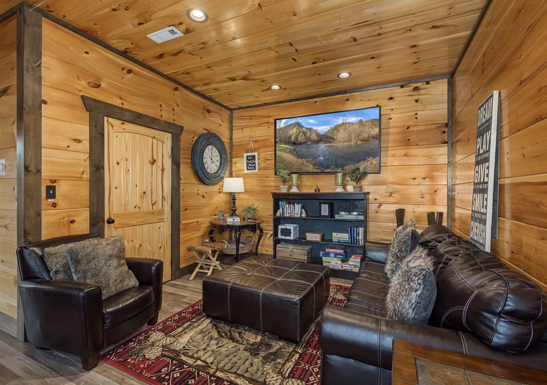 Sink into plush leather seating surrounded by warm knotted pine walls, where you can unwind with a book from the shelf or catch up on your favorite shows in this cozy living space.