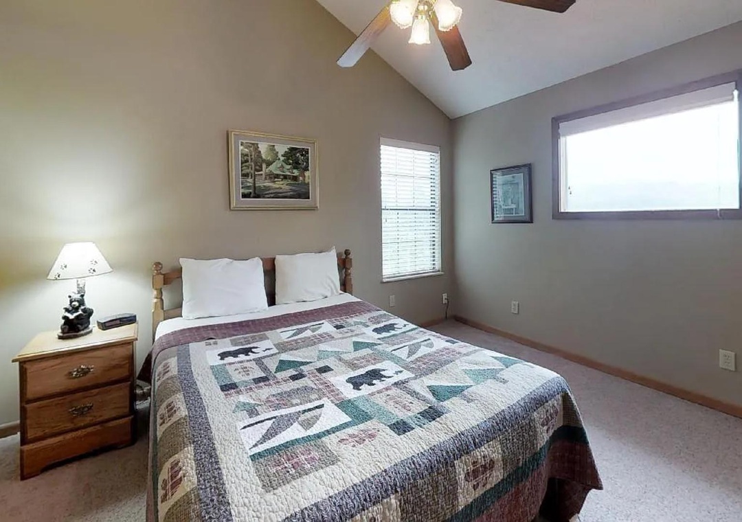 Sink into your cozy bed beneath vaulted ceilings and a gentle ceiling fan, with natural light streaming in to brighten your restful retreat.