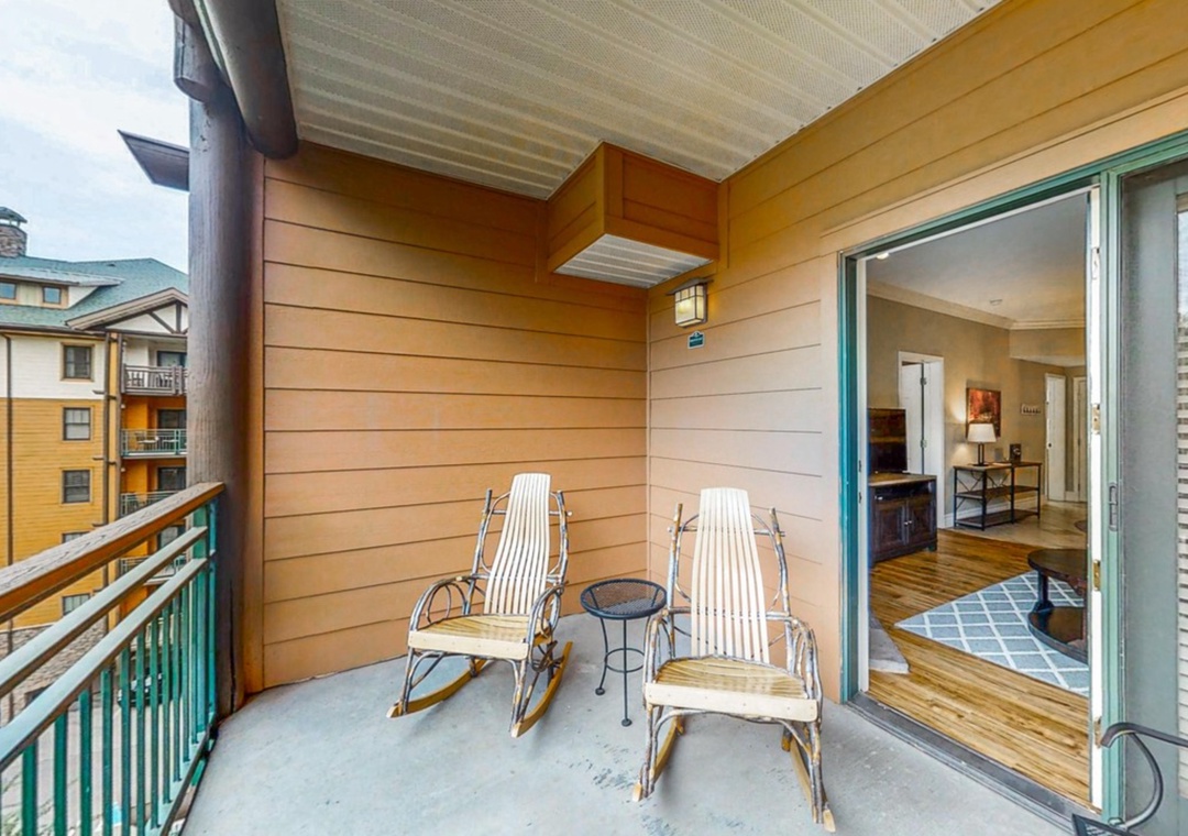 Your private balcony beckons with two rocking chairs and a cozy side table—perfect for morning coffee or evening relaxation.