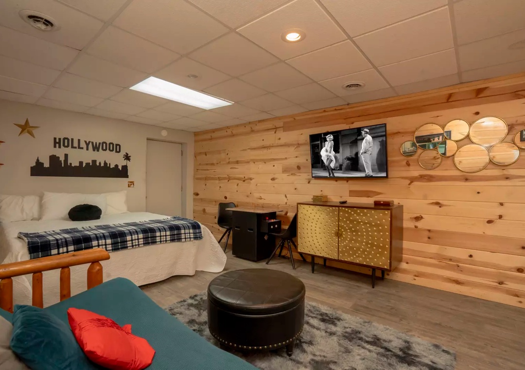 Relax in your stylish retreat featuring warm wood accents, mid-century furnishings, and entertainment setup for cozy evenings in.