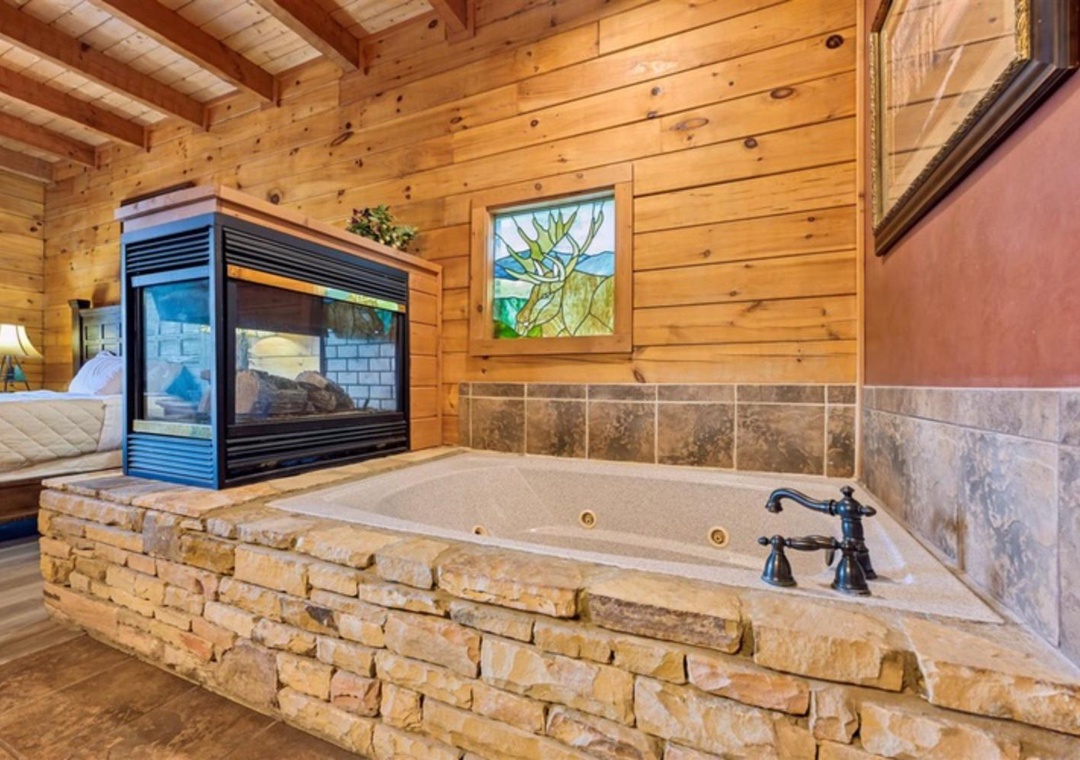 Unwind in your jetted tub with cozy fireplace views through the bedroom—pure rustic luxury after a day of mountain adventures.