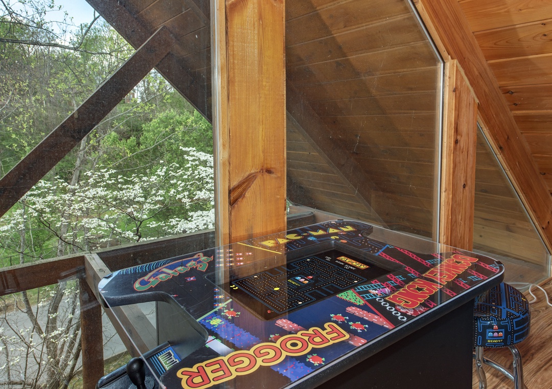 Challenge friends to classic arcade games in your private loft gaming retreat, surrounded by peaceful forest views.