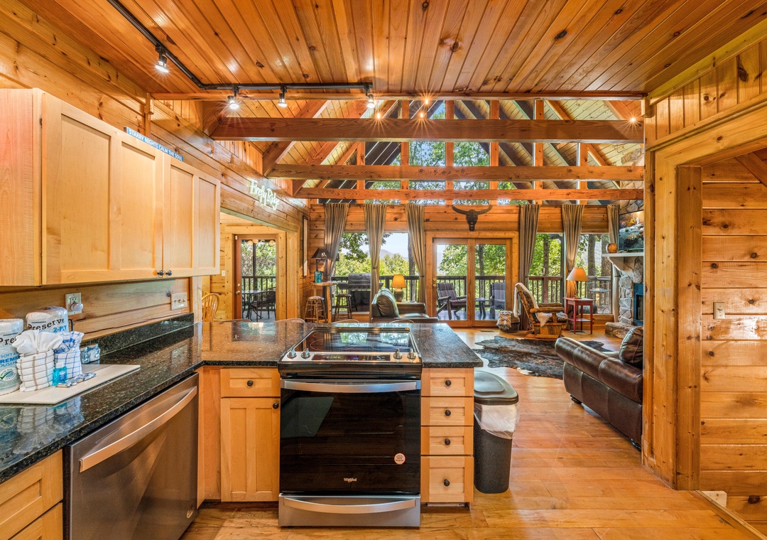 Your open-concept retreat blends a fully equipped kitchen with a cozy living area under soaring timber beams, all bathed in natural light from expansive windows overlooking the treetops.