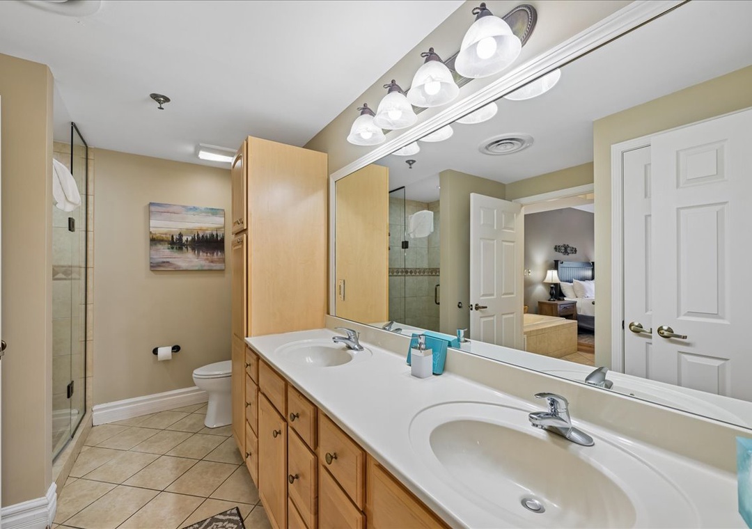 Unwind in your spacious master bathroom featuring dual vanities, a relaxing soaking tub, and a separate glass shower for ultimate comfort.