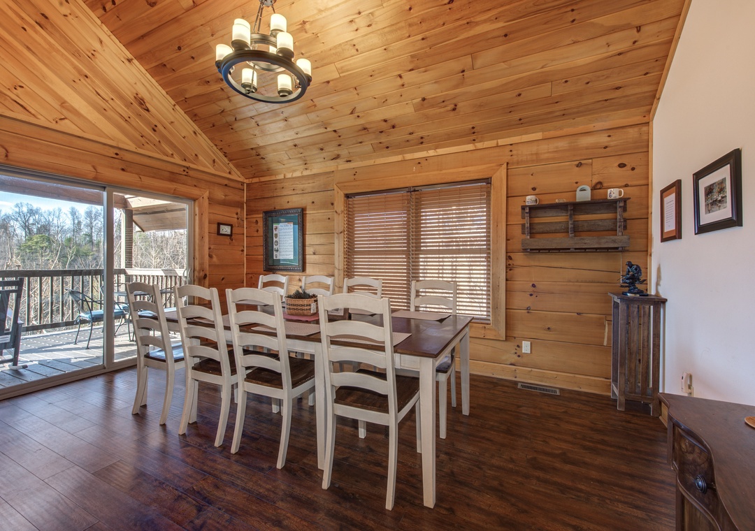 Your rustic dining space features warm wood ceilings and seating for eight, with sliding doors opening to your private deck overlooking peaceful wooded views.