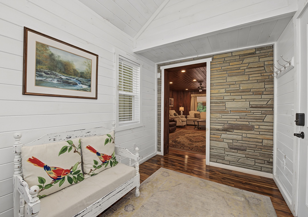 Step inside to discover rustic stone accents and warm hardwood floors leading you into a cozy living area where comfort and charm blend seamlessly.