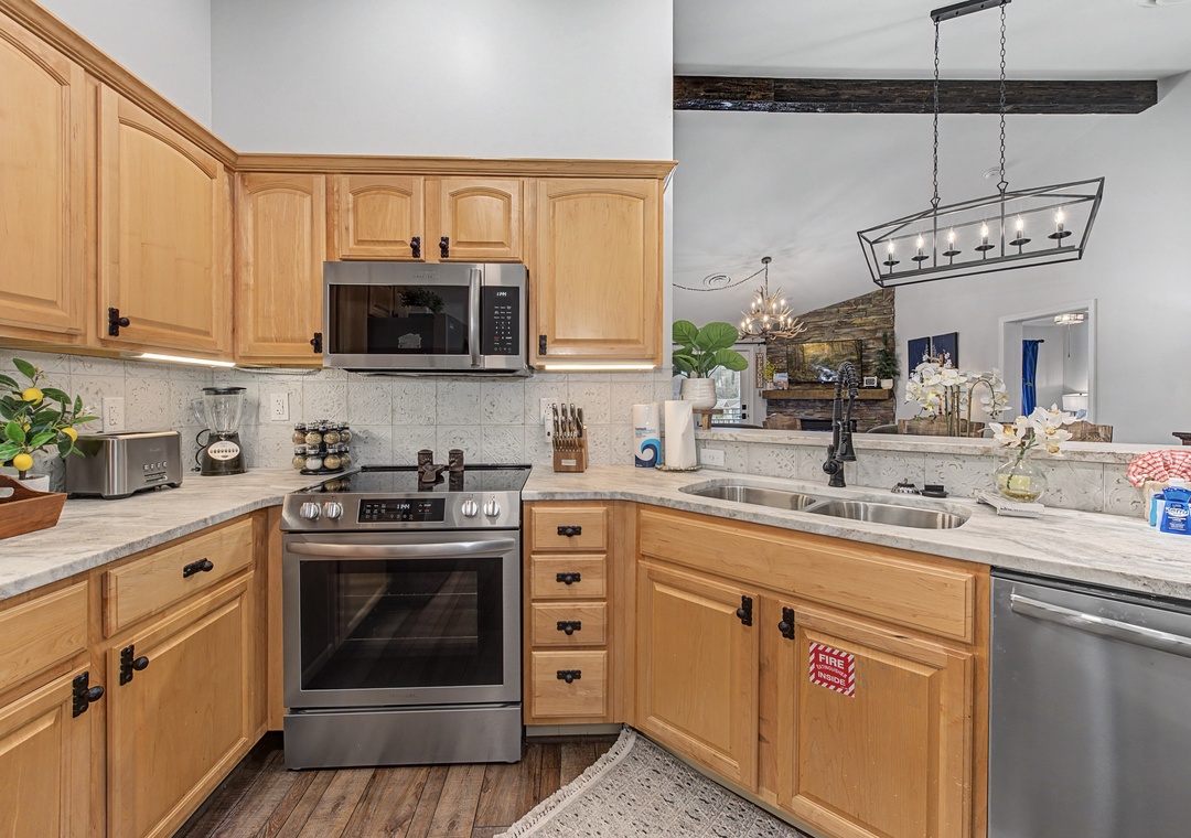Your fully equipped kitchen features warm wood cabinets, granite counters, and modern appliances ready for your culinary adventures.