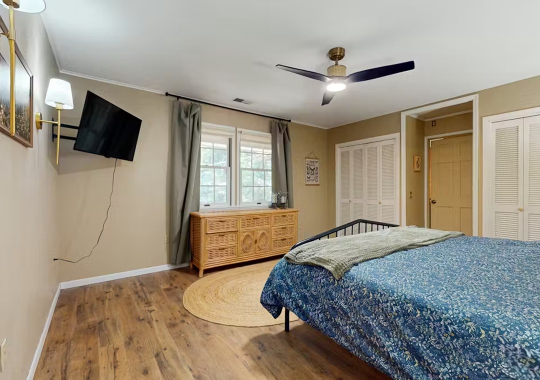 Unwind in your cozy bedroom featuring comfortable bedding, entertainment center, and ample storage for a restful stay.