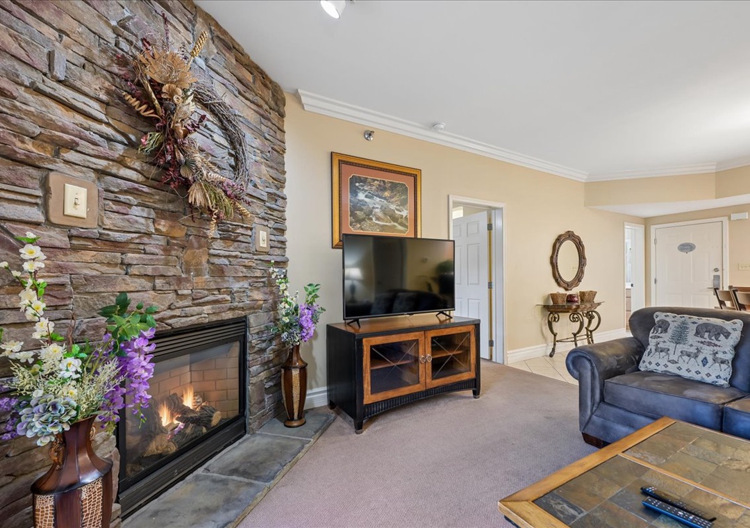 Cozy up by your private stone fireplace while watching TV in this inviting living space with rustic charm and comfortable seating.
