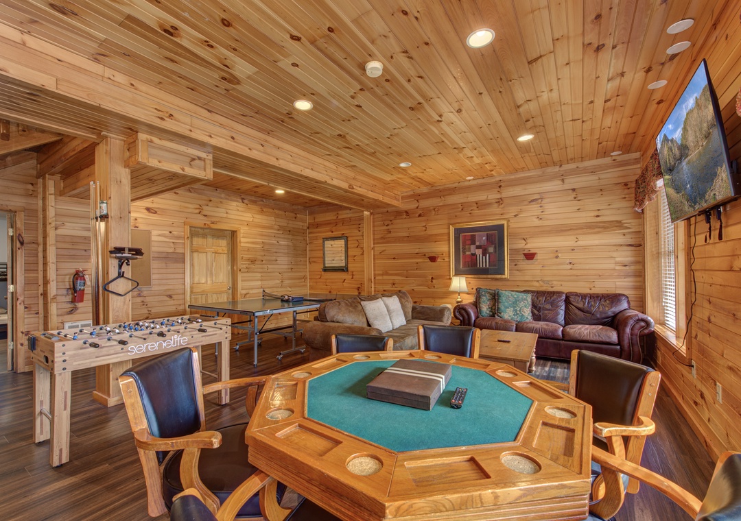 Your private game room awaits with foosball, ping pong, and poker table surrounded by warm wood.