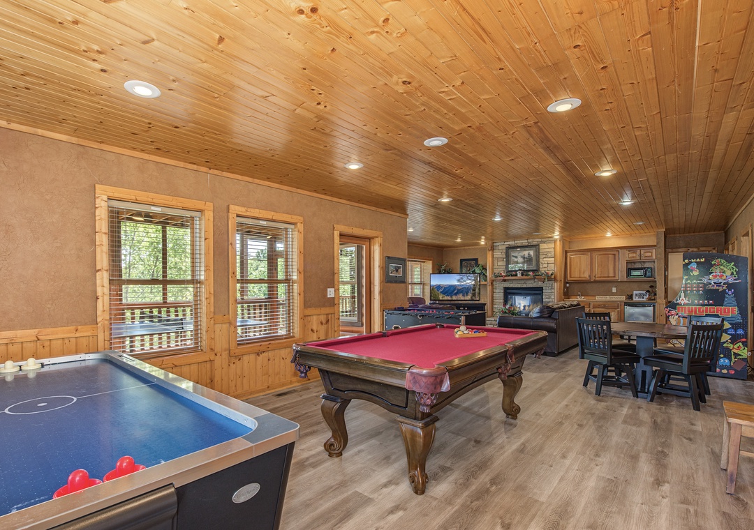 Challenge your family to a friendly game night in your private recreation room featuring a pool table, air hockey, and arcade games under beautiful wood-paneled ceilings.