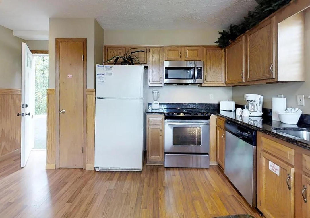 Step into your fully equipped kitchen with stainless steel appliances, smooth countertops, and warm wood cabinetry—perfect for preparing meals during your stay.