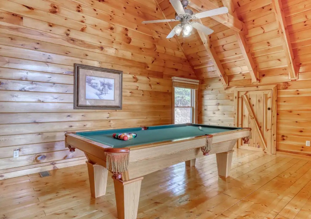 Challenge your travel companions to a friendly game of pool in this inviting loft space, where warm wood surrounds you and natural light streams through the window.