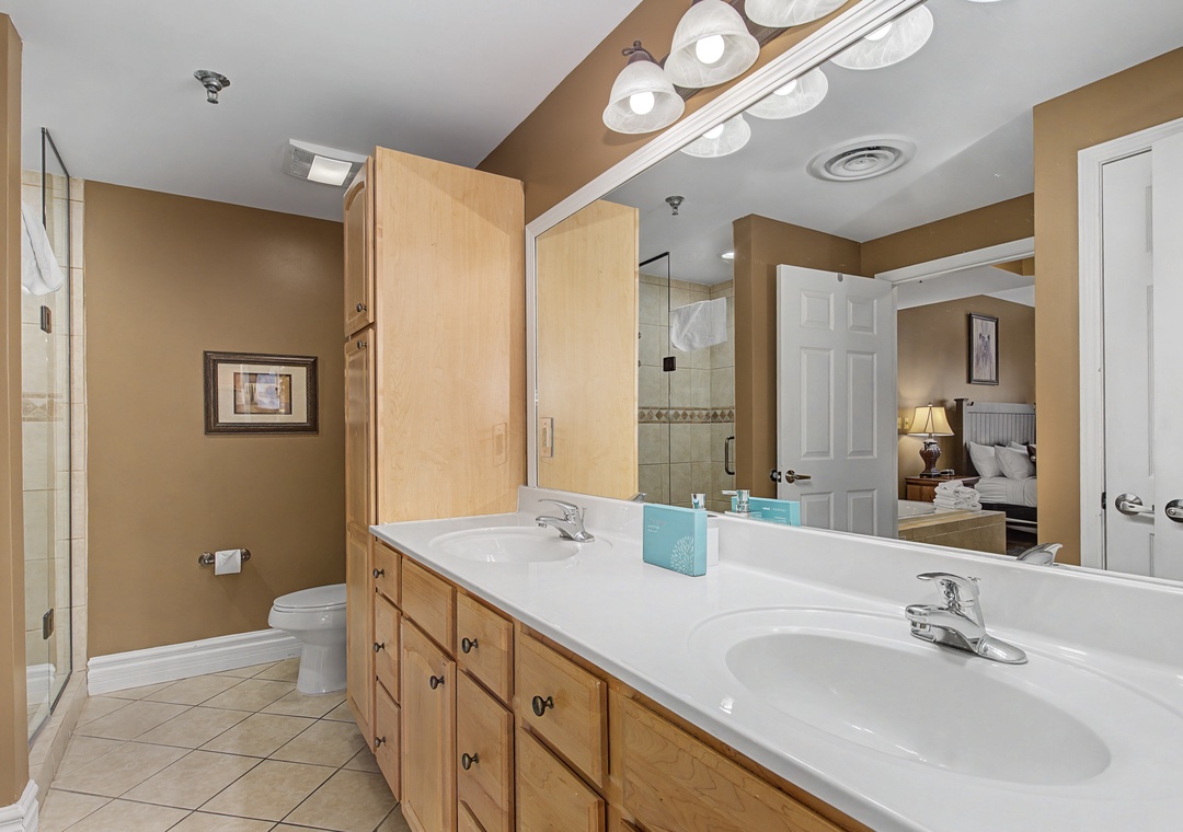 Spacious master bathroom with dual vanities, elegant lighting, and glass shower—your perfect sanctuary for relaxation.