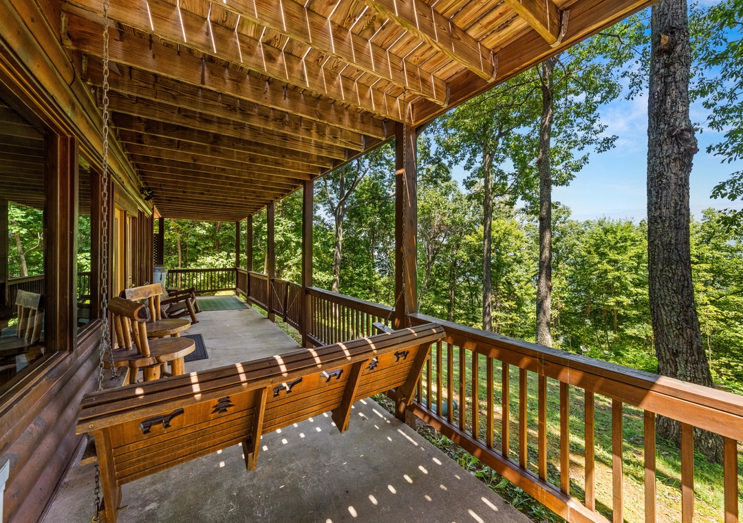 Picture yourself swaying gently on the wooden porch swing, surrounded by lush forest views and dappled sunlight filtering through the trees—your peaceful retreat awaits.