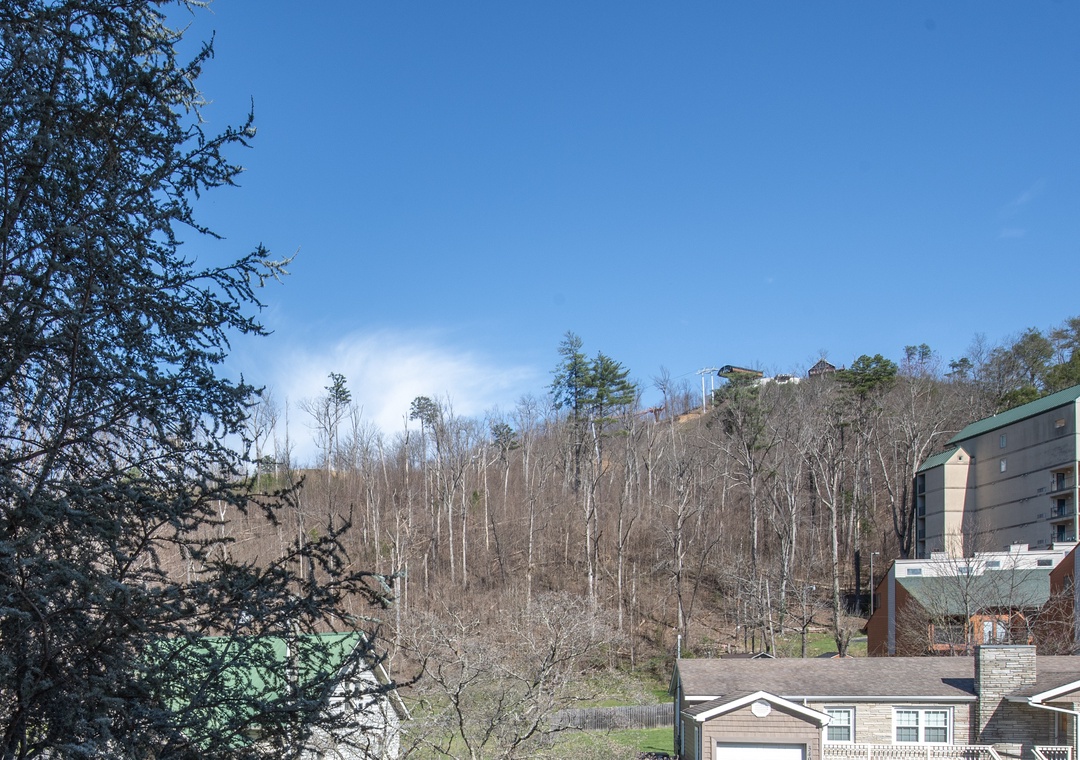 Mountain landscape surrounds the property with bare winter trees and clear blue skies creating a peaceful hillside setting.