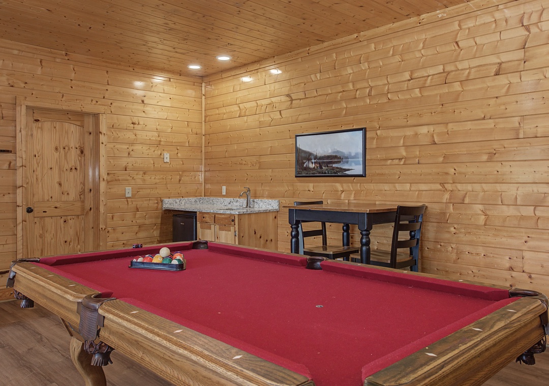 Challenge friends to a game in your private billiards room, featuring rustic wood walls and cozy cabin charm.