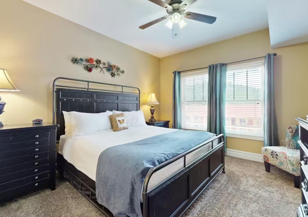 Sink into comfort in your serene bedroom retreat with plush bedding, gentle ceiling fan, and natural light streaming through your windows.