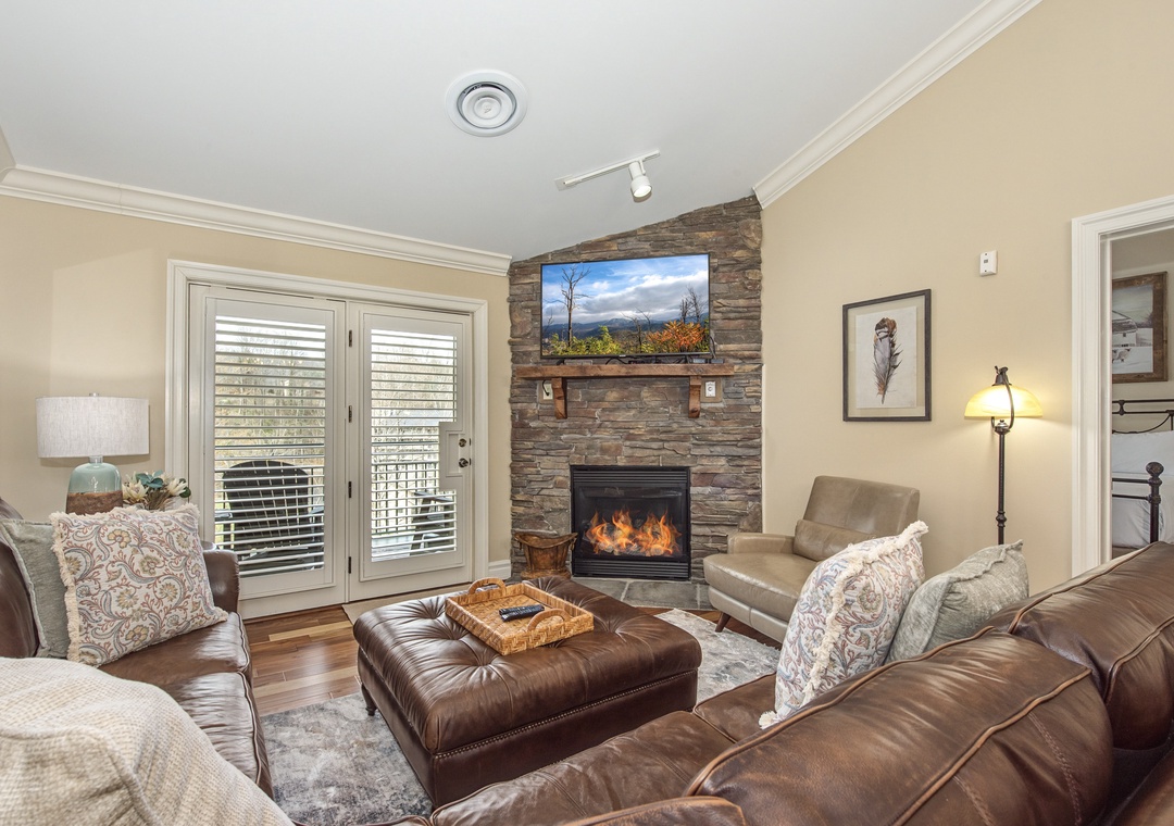 Curl up in this cozy living room where leather seating surrounds a crackling stone fireplace, perfect for your mountain getaway evenings.