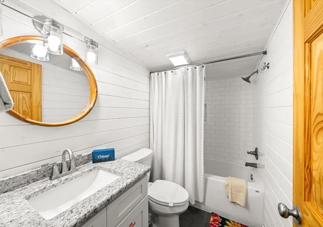 Step into your fresh, bright bathroom with crisp white shiplap walls and subway tile shower. A spacious granite-topped vanity and soft towels await after your relaxing soak.