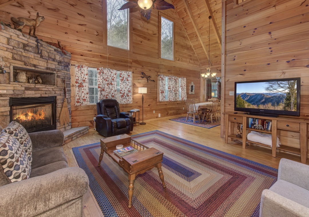 Cozy up in this rustic living room where warm wood surrounds you, a crackling fireplace beckons, and mountain views await on the big screen.