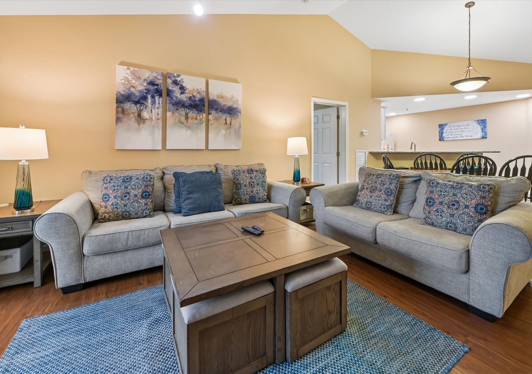 Sink into plush gray sofas surrounded by coastal blues and warm lighting, creating your perfect retreat for evening conversations.