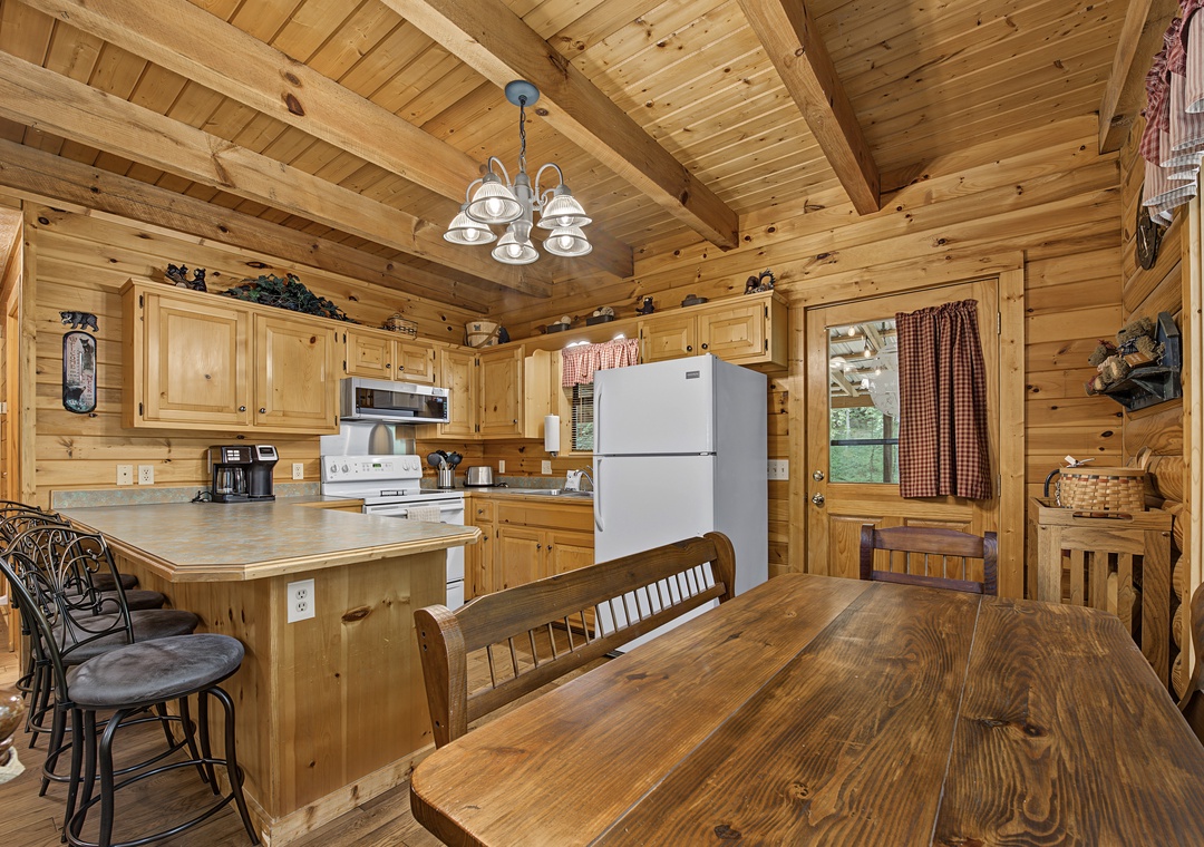 Cook together in this charming wood-clad kitchen where rustic meets comfort. Vaulted ceilings, warm wood tones, and a cozy breakfast bar create the perfect gathering spot for your group.
