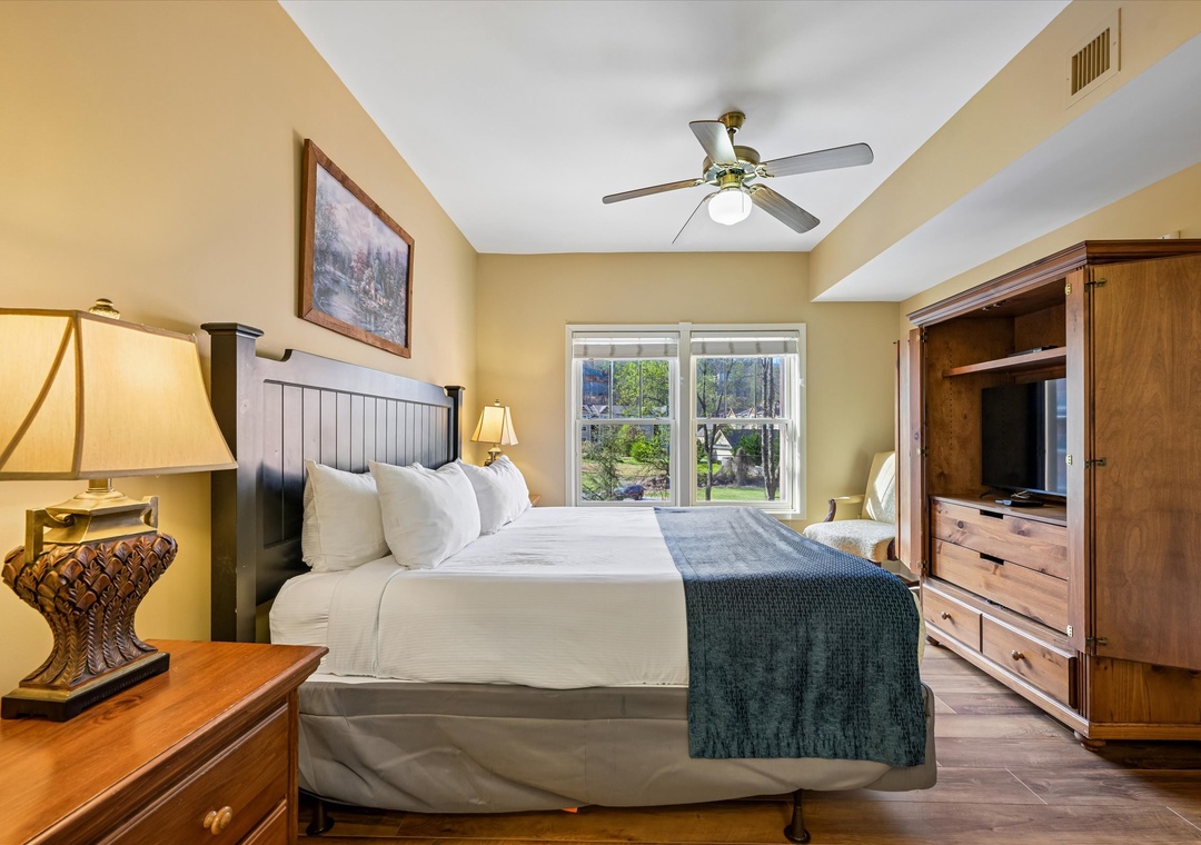 Unwind in your comfortable bedroom with warm wood furnishings, soft linens, and garden views through bright windows.