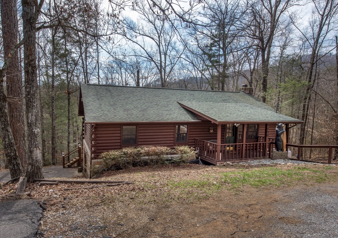 A charming log cabin retreat nestled among tall trees in a peaceful wooded setting, offering rustic comfort and natural tranquility.