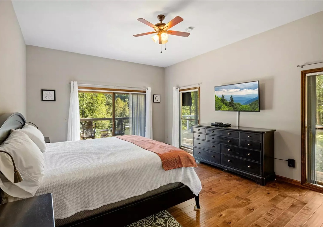 Drift off to sleep surrounded by natural beauty, where your ceiling fan keeps you cool and large windows frame forest views that greet you each morning.