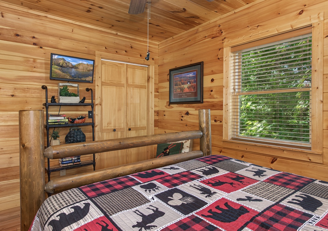 Wrap yourself in plaid comfort under soaring pine ceilings, where your rustic log bed frames green garden views and cozy cabin charm.