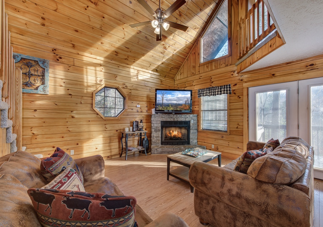 Relax in your cozy living room where warm wood surrounds you and the stone fireplace crackles softly as you unwind.