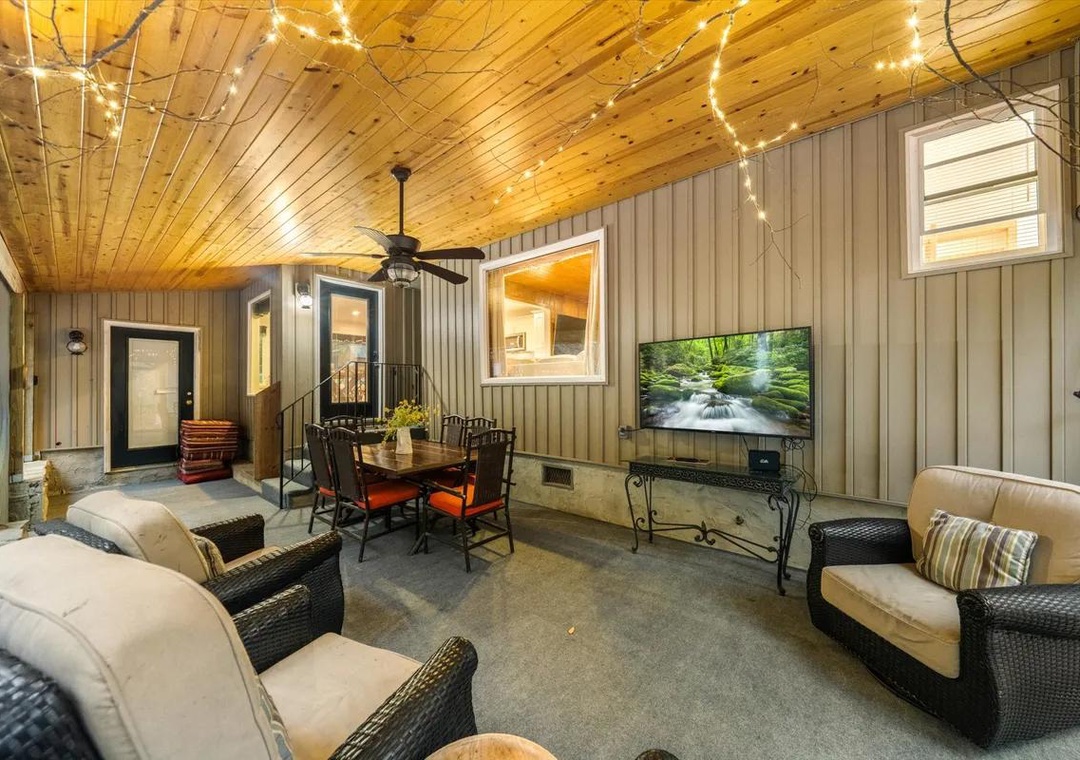 Your private screened porch glows under warm wood ceilings and twinkling lights, perfect for evening meals and relaxed conversation no matter the weather.