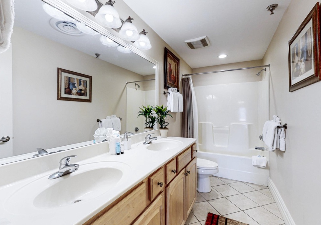 Refresh in your spacious bathroom featuring dual vanities, deep soaking tub, and bright vanity lighting for comfortable morning routines.