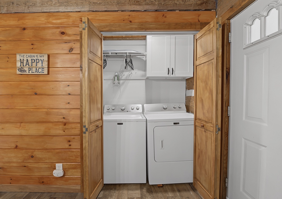 Your cabin laundry closet keeps everything tidy and convenient—washer, dryer, storage, and a cheerful sign to brighten every chore.