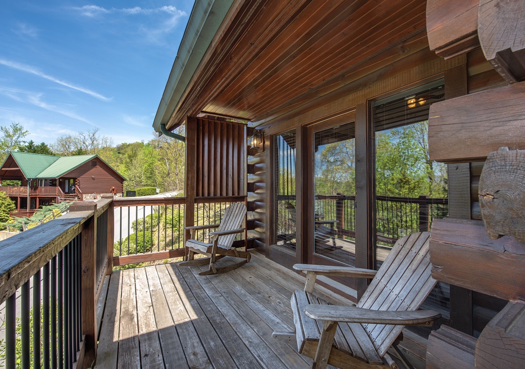 Relax on your private deck with rustic log chairs while soaking in peaceful forest views.