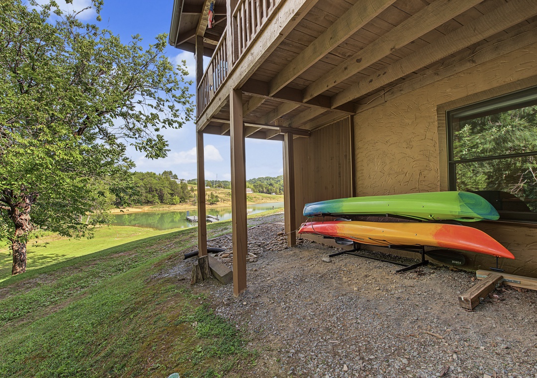 The property sits on the waterfront with kayaks ready for lake adventures. Lush greenery and a peaceful pond create a scenic backdrop for your stay.